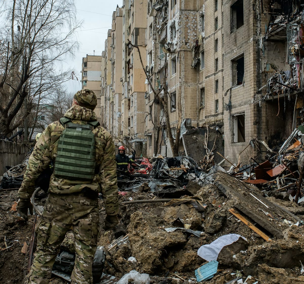 a man in camouflage walking through a destroyed building
