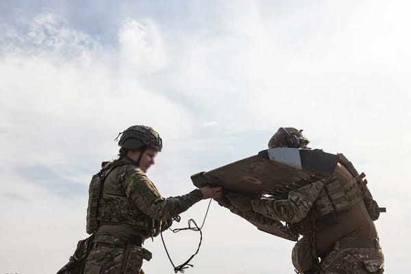 Ukrainian soldiers handling a drone, preparing for launch as part of strategy to evade Russian air defenses