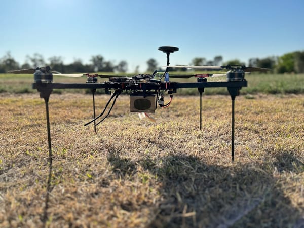 A long-range Ukrainian drone with multiple rotors standing in a field.